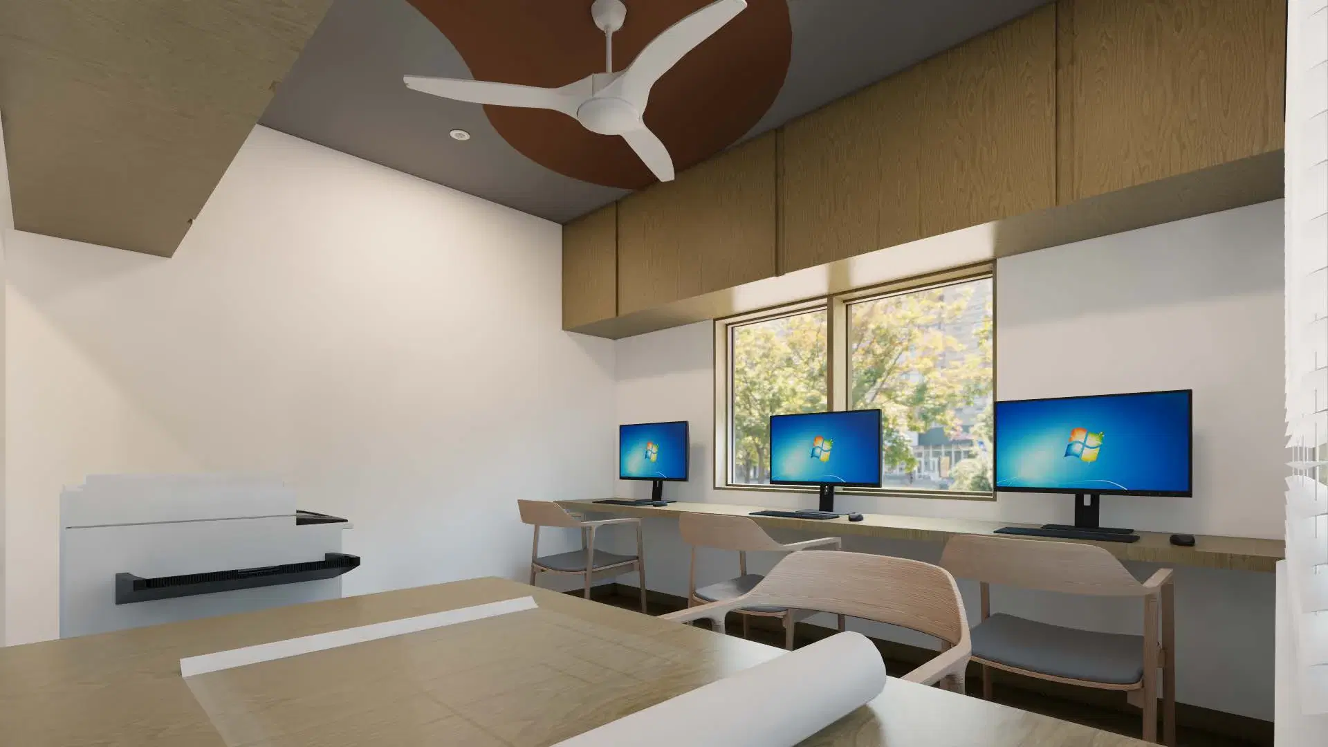 SRM Office, Madaiyur — the workstation room from the opposite end, the plan table in the foreground and monitors beyond.